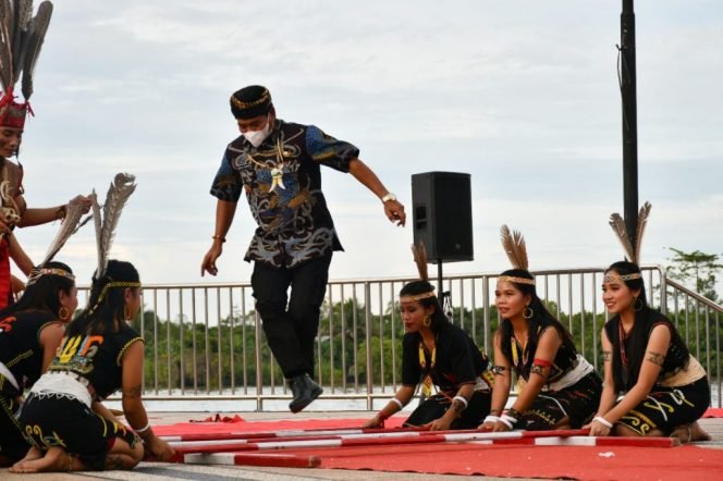 
					Mengenakan singal, Gubernur Zainal mengikuti permainan khas suku Dayak Kaltara. Foto : Dkisp Kaltara 