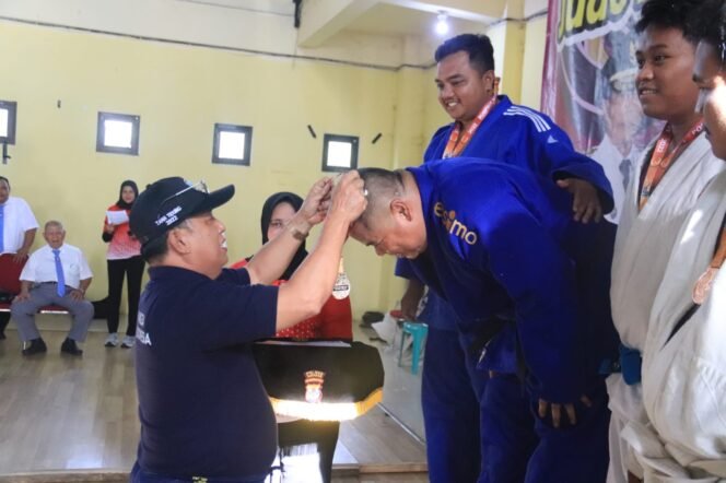
					Ketua Tim Porprov KTT Hendrik, saat mengalungkan mendali emas kepada Atlet Judo. Foto: ist