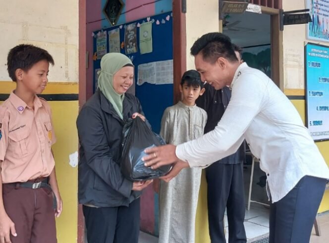 
					Kepala SDN 014 Kota Tarakan Elymius Limbong serahkan bantuan paket sembako. Foto : ist.