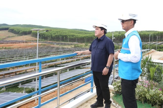 
					Menteri BUMN Erick Thohir (kiri) bersama Direktur Utama PLN Darmawan Prasodjo (kanan) saat meninjau pembangkit listrik tenaga surya (PLTS) Ibu Kota Nusantara, di Penajam Paser Utara, Kalimantan Timur, Sabtu (29/6).
