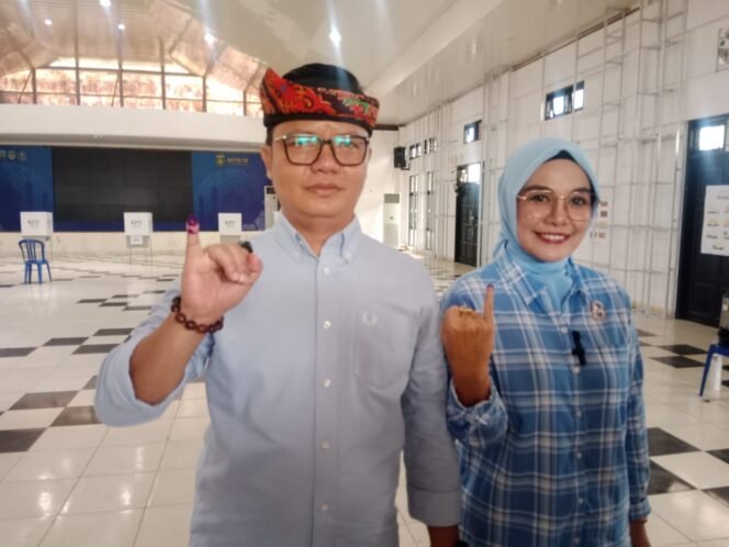 
					 Kompak menggunakan baju berwarna biru Bupati Tana Tidung Ibrahim Ali dan istri Vamelia menggunakan hak suaranya untuk mencoblos di TPS 7 Desa Tideng Pale, Rabu (27/11/2024).


