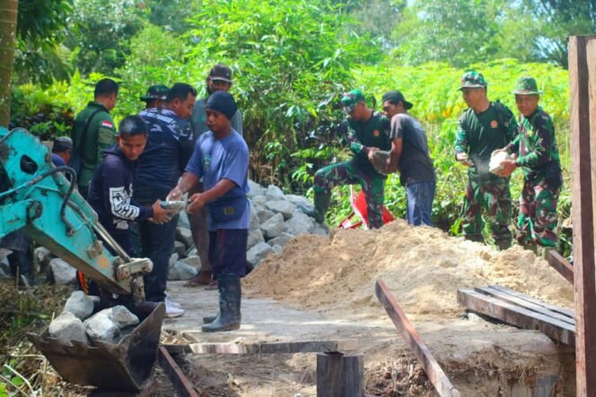 
					TNI dan warga bersama-sama membangun pondasi jembatan

