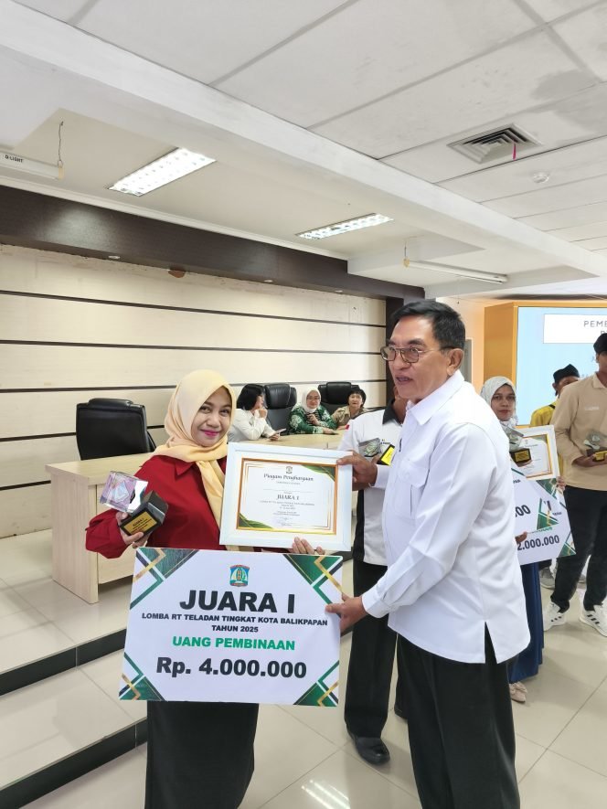 
					Ketua RT 49 Kelurahan Gunung Sari Ilir (GSI), Hj Herly Yunita Antul menerima hadiah dari dewan juri yang merupakan Ketua Asosiasi DPD LPM Kota Balikpapan Damanhury.
