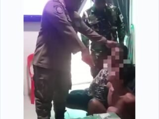 Salah satu petugas Pol PP yang terlihat di video, tampak menunjukkan 12 kg barang bukti. (Foto: Ist)