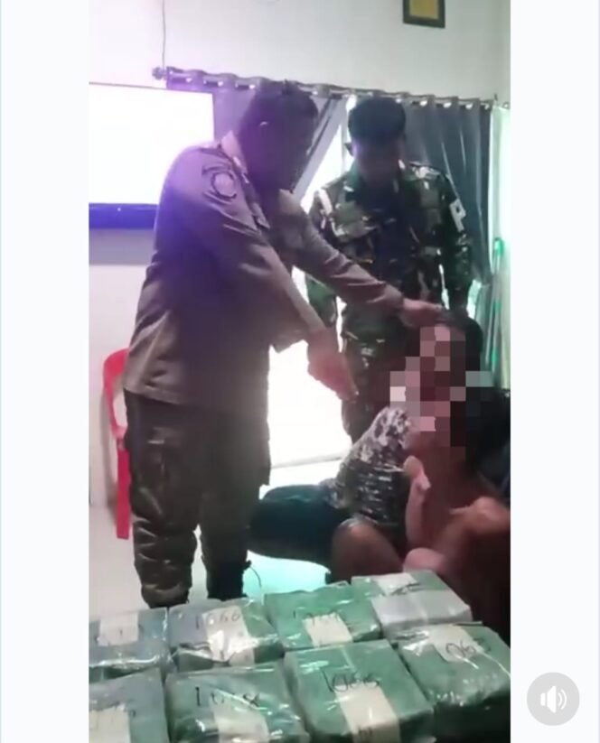 
					Salah satu petugas Pol PP yang terlihat di video, tampak menunjukkan 12 kg barang bukti. (Foto: Ist)